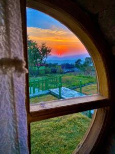 widok na zachód słońca przez okno w obiekcie Hobbit House Bir w mieście Bir