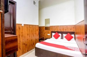 a bedroom with a bed with red pillows at OYO Flagship Shri Sai Guest House in New Delhi
