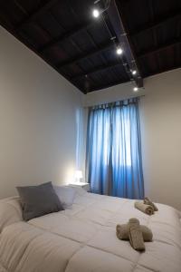 1 dormitorio con 1 cama grande y cortinas azules en La Casa del Palio, en Ronciglione