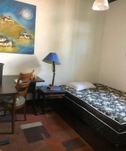 um quarto com uma cama e um candeeiro sobre uma mesa em Casa Moinhos de Vento Vintage em Porto Alegre