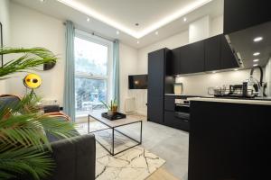 a kitchen with a couch and a table in a room at One & Two Bedroom Apartments near Holloway Train Station by Belvilla in London