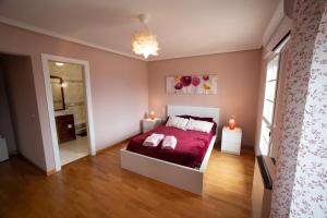 1 dormitorio con 1 cama con sábanas rojas y 2 lámparas en CASA DOVELA, en Jarandilla de la Vera