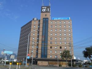 Un edificio alto con una torre de reloj en la parte superior. en Hotel Alpha-One Yamaguchi Inter, en Yamaguchi