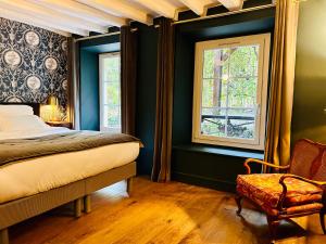 ダンピエールにあるL’Auberge du Châteauの緑の壁のベッドルーム1室、ベッド1台、椅子1脚が備わります。