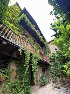 an ivy covered building with a walkway and a balcony at La Casa del Bosque in Cabra de Mora
