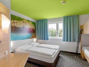 ハンブルクにあるB&B Hotel Hamburg-Wandsbekのベッド2台と窓が備わる客室です。