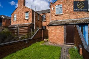 un bâtiment en briques avec une cour d'herbe devant lui dans l'établissement Spacious Victorian House By AV Hughes Properties Short Lets & Serviced Accommodation Northampton with Fast Wi-Fi and Free Parking, à Northampton