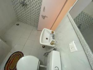 a small bathroom with a toilet and a sink at Metro Nook in Lucknow