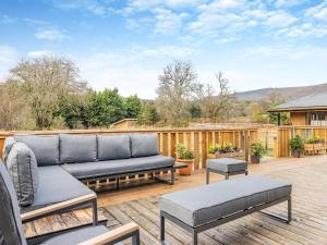 a patio with a couch and chairs on a deck at Lime Lodge - Uk42547 in Llanwrthwl
