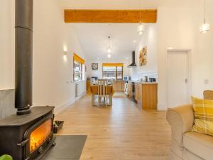 a kitchen and living room with a stove at Lime Lodge - Uk42547 in Llanwrthwl