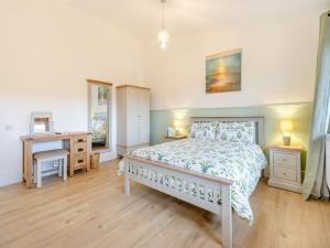 a bedroom with a bed and a desk and two windows at Lime Lodge - Uk42547 in Llanwrthwl