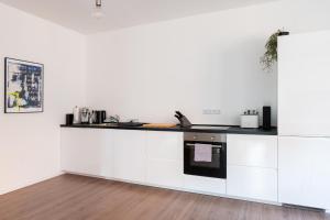 a kitchen with white cabinets and a counter top at Luxuriöses Apartment, 10min Innenstadt, Parkplatz in Erfurt +21 photos