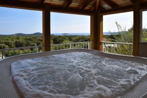 a jacuzzi tub on the porch of a house at Résidence Chiar' Di Luna in Sainte-Lucie de Porto-Vecchio