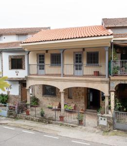 uma casa antiga com uma varanda numa rua em CASA DOVELA em Jarandilla de la Vera