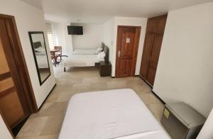 卡利的住宿－Hotel Ciudad Capri，一间带床和镜子的客厅