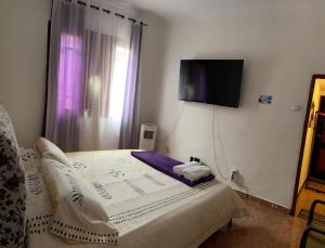 a bedroom with a bed with a tv on the wall at Home JV in Getafe