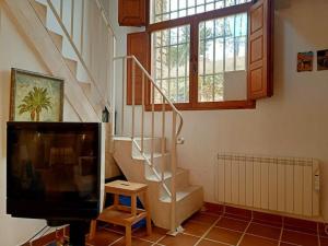 sala de estar con TV y escalera en Casita de ensueño, en la sierra de Segovia, en Segovia