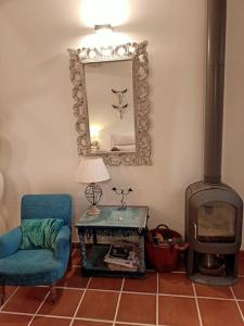 a living room with a blue chair and a mirror at Casita de ensueño, en la sierra de Segovia in Segovia