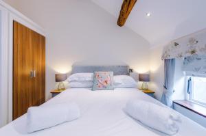 a bedroom with a large white bed with two pillows at Stunning 3-bed cottage in Beeston by 53 Degrees Property, ideal for Families & Groups, Great Location - Sleeps 6 in Beeston