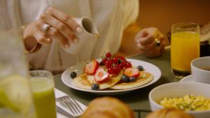 a woman sitting at a table with a plate of food at Royal Madeleine Hotel & Spa in Paris