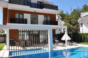 een villa met een zwembad en een huis bij Hisar Prestige D in Fethiye