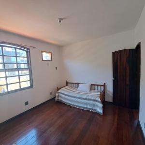 1 dormitorio con cama y ventana grande en Casa para fins de semana e curta temporada, en Río de Janeiro