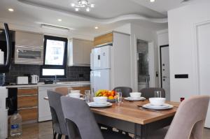 een keuken en eetkamer met een houten tafel en stoelen bij Hisar Prestige D in Fethiye