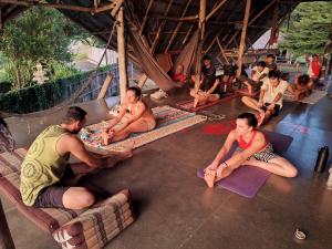 un groupe de personnes assises à même le sol dans l'établissement Cody Backpackers, à Pai