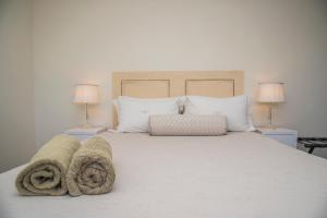 ein Schlafzimmer mit einem weißen Bett mit Handtüchern darauf in der Unterkunft Grootvlei Guest Farm in Lambertʼs Bay