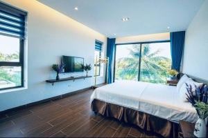 a bedroom with a large bed and a large window at Villa FLC Sầm Sơn - Cạnh Bể Bơi Vô Cực in Sầm Sơn