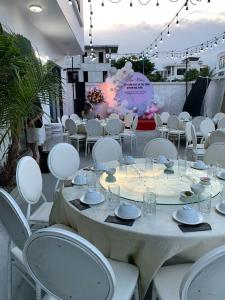 a table with white chairs and a table set up for a party at Villa FLC Sầm Sơn - Cạnh Bể Bơi Vô Cực in Sầm Sơn
