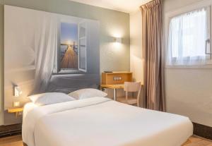 ラ・セーヌ・シュル・メールにあるB&B HOTEL Toulon La Seyne sur Merの白いベッドと窓が備わるホテルルームです。