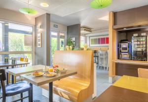 a dining room and kitchen with a table and chairs at B&B HOTEL Toulon La Seyne sur Mer in La Seyne-sur-Mer