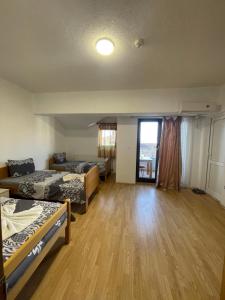a large room with two beds and a window at Ela Hostel in Prizren
