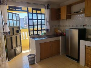 a kitchen with a stainless steel refrigerator and a window at Wike Suites in Nakuru