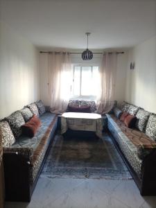 a living room with a couch and a table at appartement plage Bouznika in Bouznika