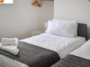 a bedroom with a bed with white sheets and pillows at Wilsons in Golspie