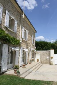 a brick building with white doors and windows at Chambres à la maison Hermitage in Aincourt