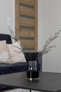 wazon z gałęziami na stole przed kanapą w obiekcie Modern 2-Bedroom Apartment in Krakow by Renters w Krakowie