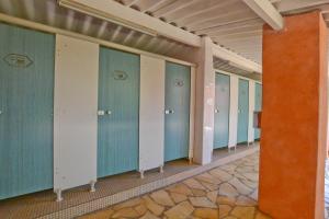 szereg szafek w budynku z niebieskimi drzwiami w obiekcie Camping U Pirellu w mieście Porto-Vecchio