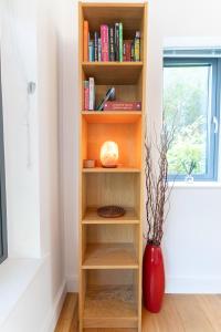 a book shelf in a room with a red vase at Executive High-End Luxury Accommodation in Southampton, Perfect for Relocators, Contractors and Professionals in Southampton