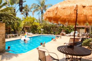 a group of people in the swimming pool at a resort at Ganesh Chalés in Boracéia