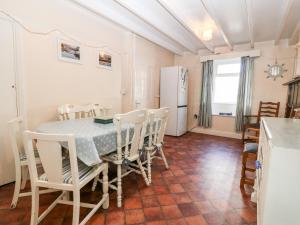 Una cocina y un comedor con mesa y sillas. en 2 Bryn Hyfryd, en Abersoch