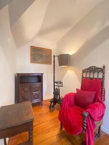 ein Zimmer mit einem Bett mit einer roten Decke darauf in der Unterkunft Au Temps Des Chevaliers in Pau