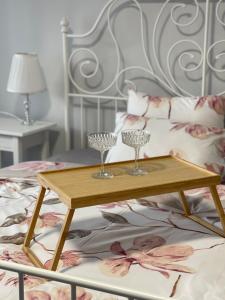 a wooden tray with wine glasses on a bed at ROTUŠĖS g 23 APARTMENTS IN THE CITY CENTER BIRŽAI in Biržai