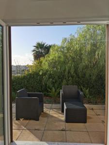 a patio with two chairs and a couch outside at Casa Porto Palo in Porto Palo