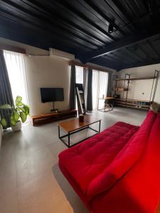 a living room with a red couch and a tv at Rumah Kahyangan in Canggu
