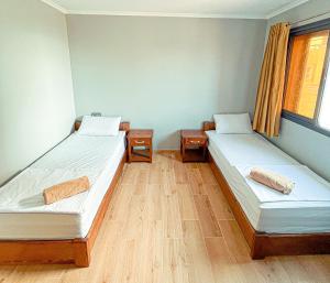 2 camas en una habitación con suelo de madera en corner House, en Imsouane