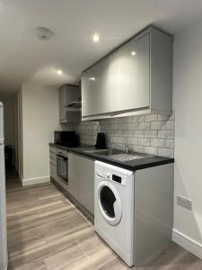 a kitchen with a washing machine and a sink at One Bedroom Apartment in Luton Town Centre in Luton