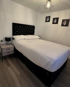 a bedroom with a large bed with a black headboard at One Bedroom Apartment in Luton Town Centre in Luton
